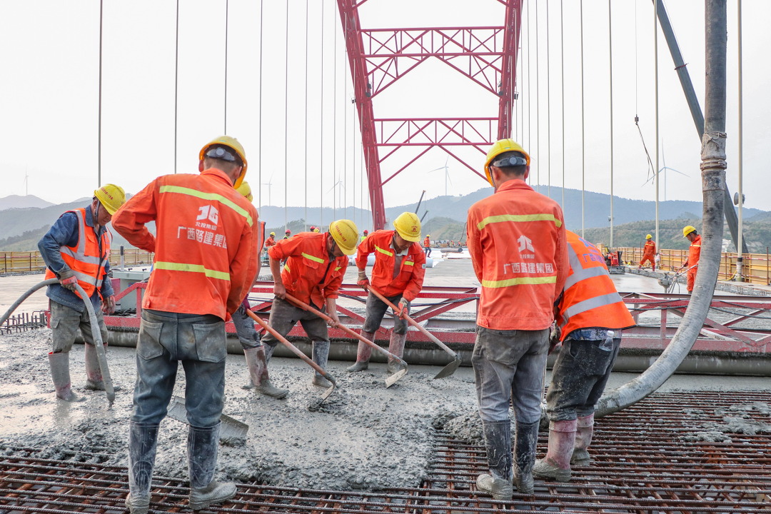 劳务工人进行主桥桥面混凝土铺装 - 广西路建集团平陆运河旧州特大桥主桥桥面混凝土浇筑完成