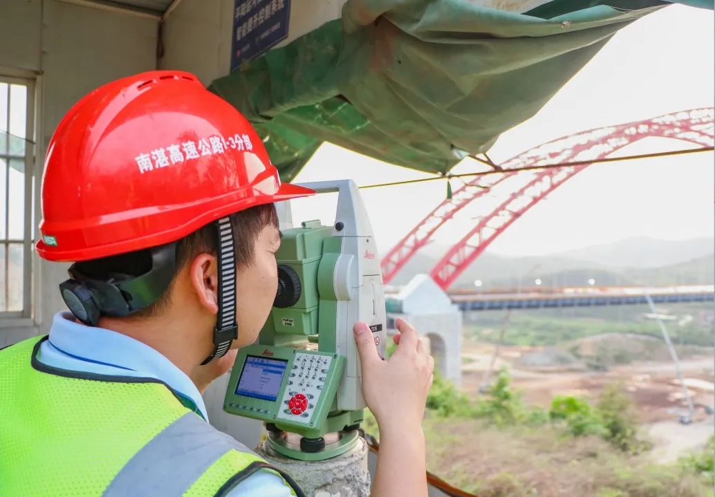 现场管理人员实时监测桥面混凝土铺装标高 - 广西路建集团平陆运河旧州特大桥主桥桥面混凝土浇筑完成